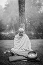 KUSHINAGAR, INDIA - DECEMBER 6, 2016: A Buddhist monk meditates at the BuddhaÃ¢â¬â¢s Cremation Stupa.